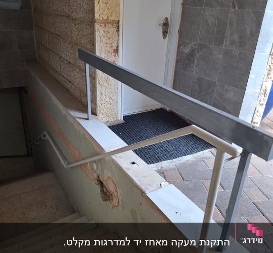 מעקה מתכת ליד מדרגות ודלת כניסה
